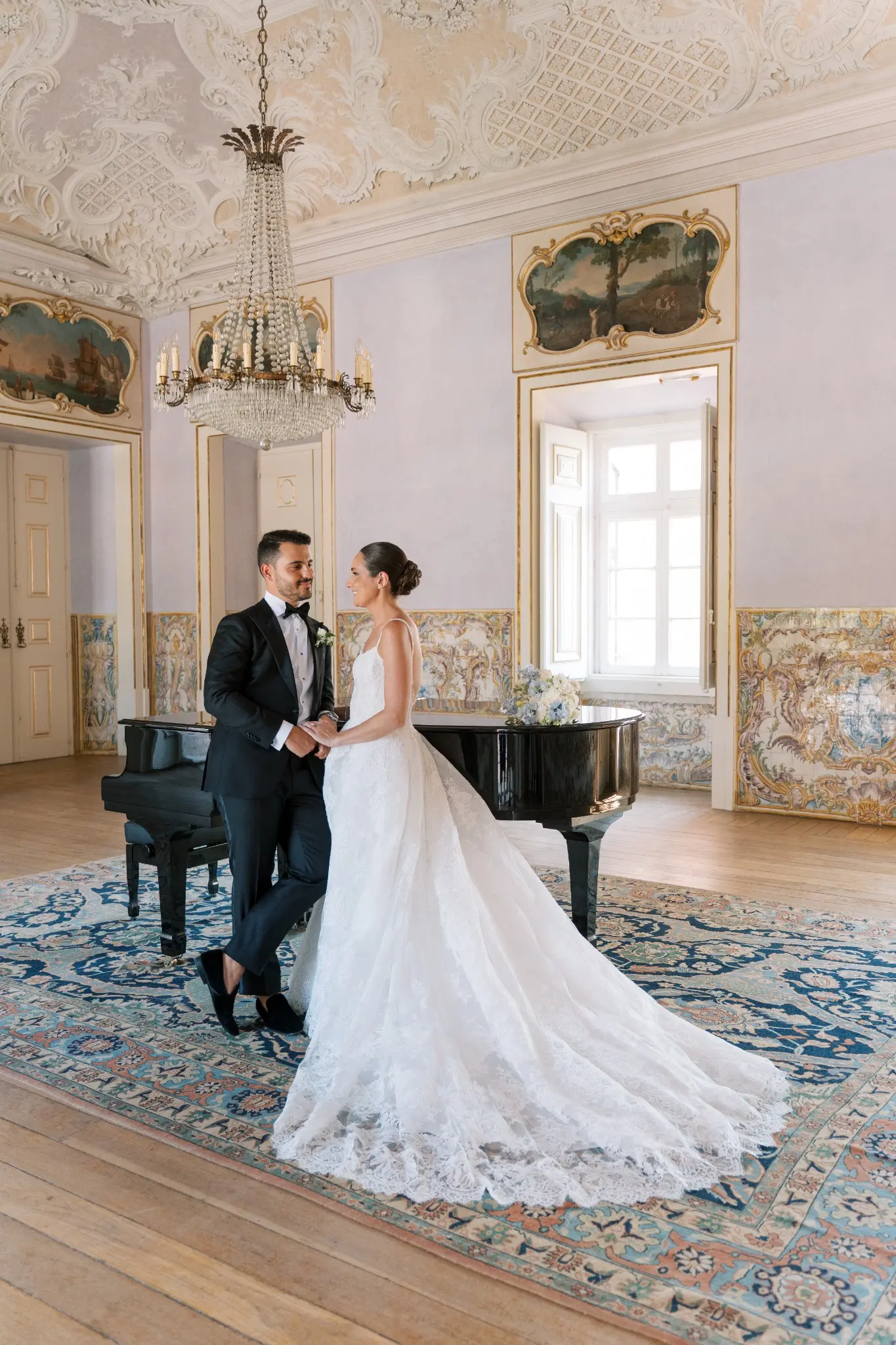 Dana and Miguel beside a grand piano in a historic Lisbon interior