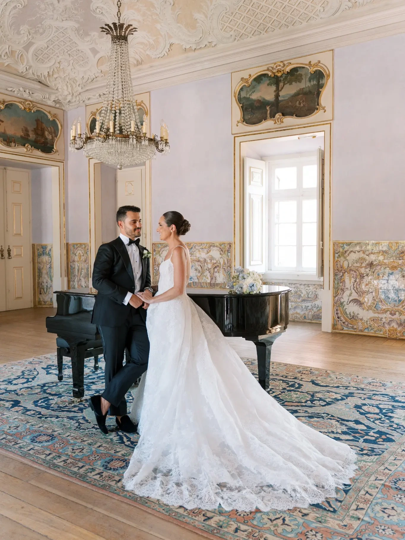 Dana and Miguel beside a grand piano in a historic Lisbon interior