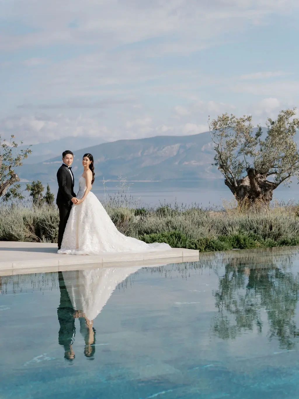 Yi Jia and Stuart reflected in the water at Amanzoe in Greece