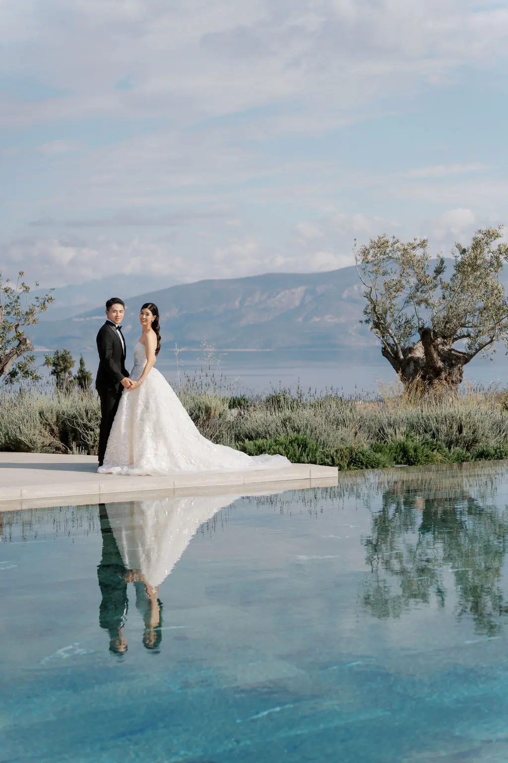 Yi Jia and Stuart reflected in the still water at Amanzoe in Greece