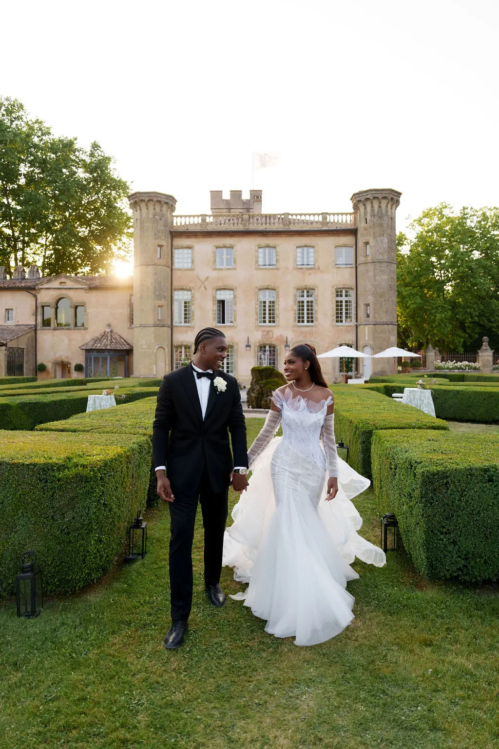 A newly married couple walking through the grounds of their wedding venue in France